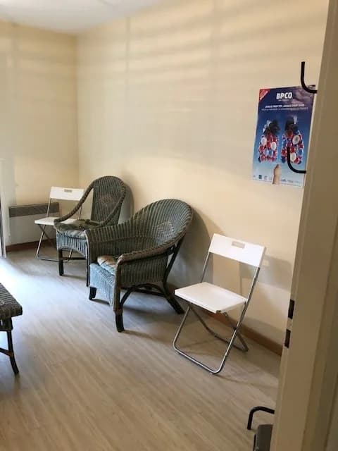 Salle d'accueil d'un local professionnel, fauteuils et chaises écartés des murs